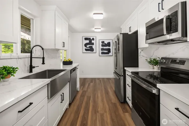 a kitchen with stainless steel appliances a refrigerator sink and microwave