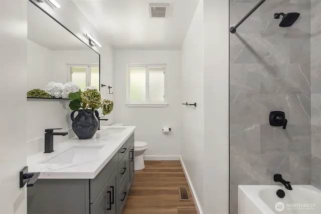 a bathroom with a sink a toilet and shower
