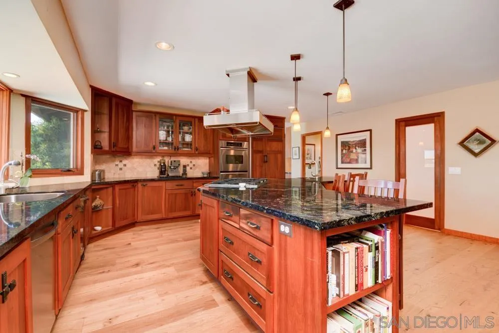 17758 Del Paso Drive Poway, CA 92064 - Photo 13 of 42 a kitchen with stainless steel appliances granite countertop a sink a stove and a wooden floors