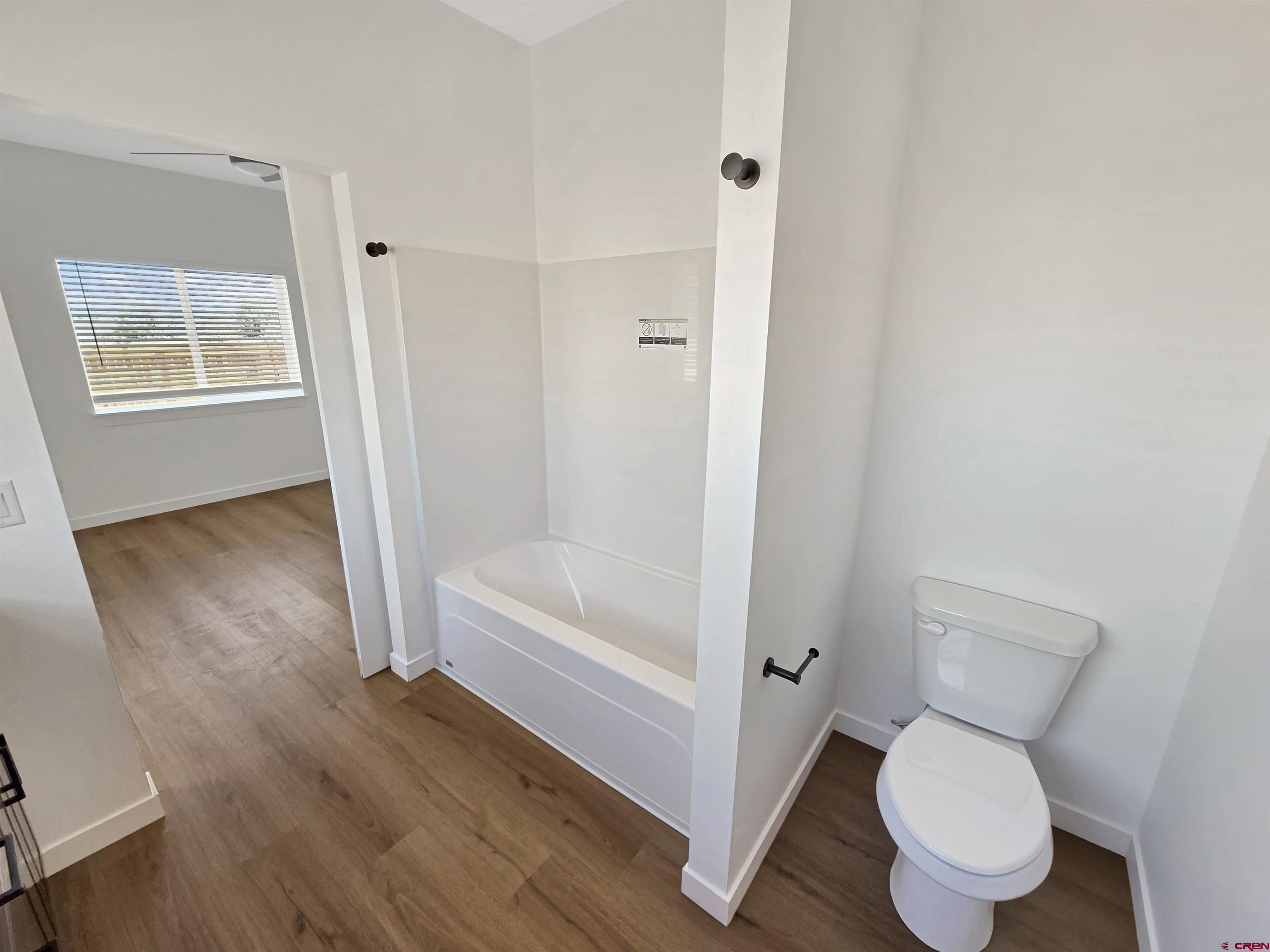 1456 Acoma Street Cortez, CO 81321 - Photo 14 of 26 a bathroom with a toilet and a bathtub