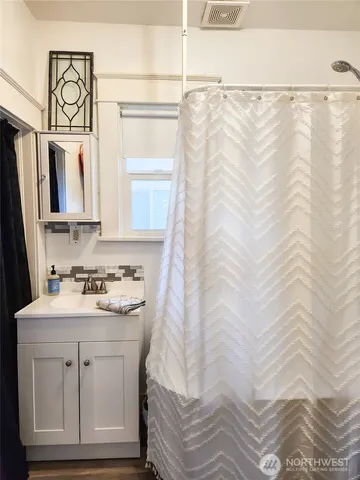 a bathroom with a sink a mirror and a shower curtain