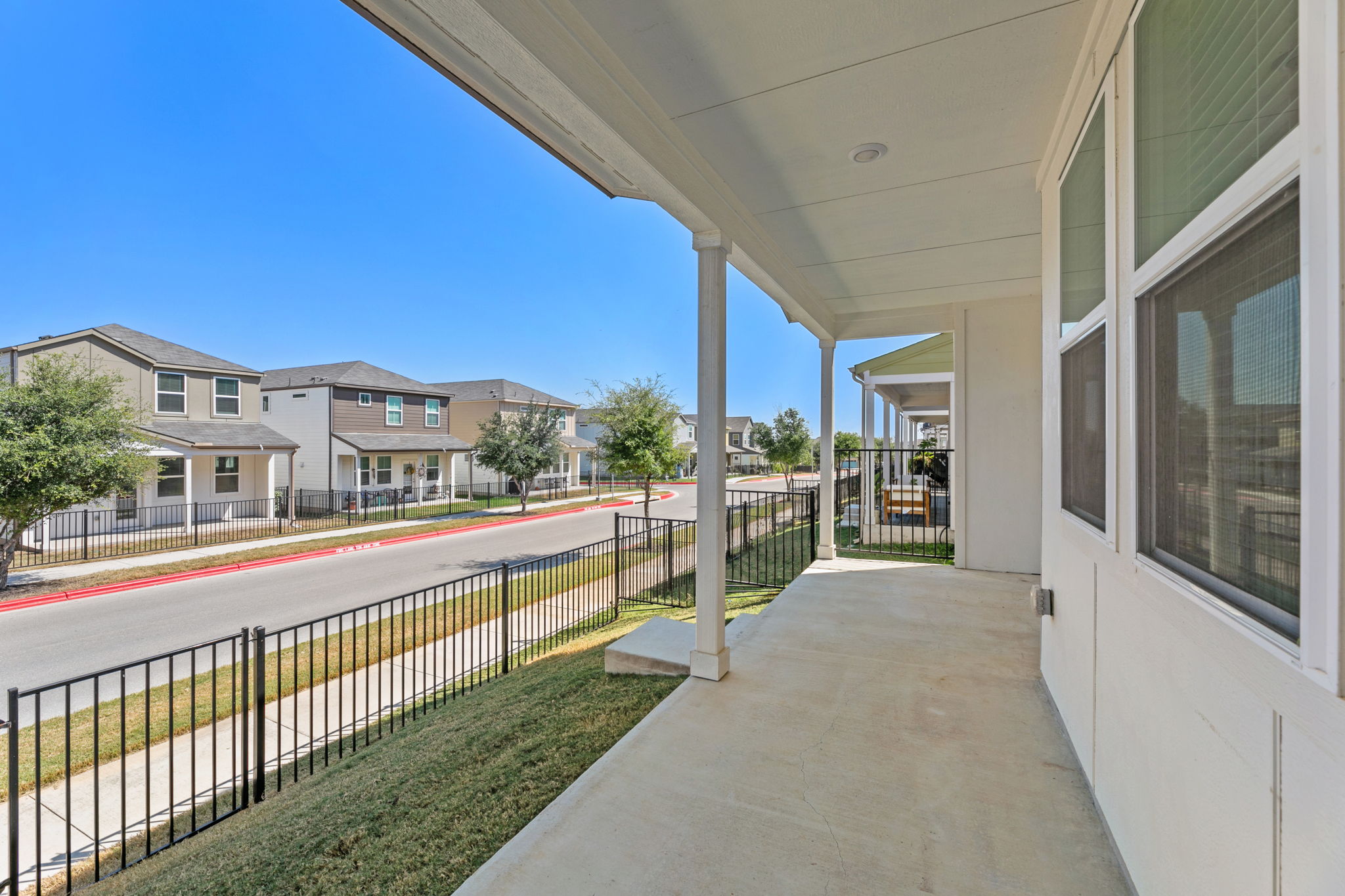 7312 Travertine Spring Drive Austin, TX 78744 - Photo 31 of 32 A welcoming covered front porch overlooks the neighborhood street, providing a serene outdoor retreat.