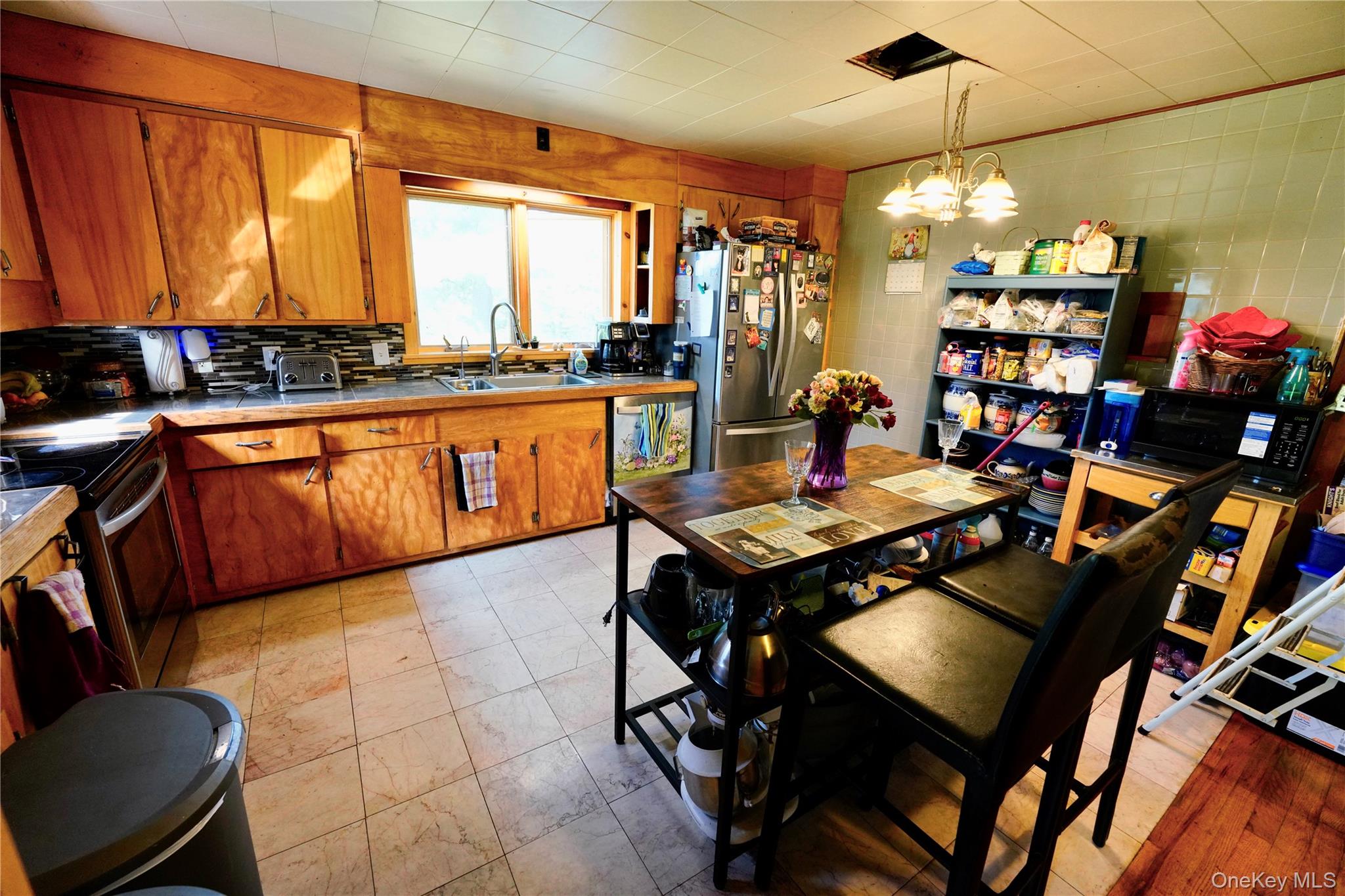 669 Shandelee Road Livingston Manor, NY 12758 - Photo 20 of 46 a living room with stainless steel appliances granite countertop a table chairs and a wooden cabinets