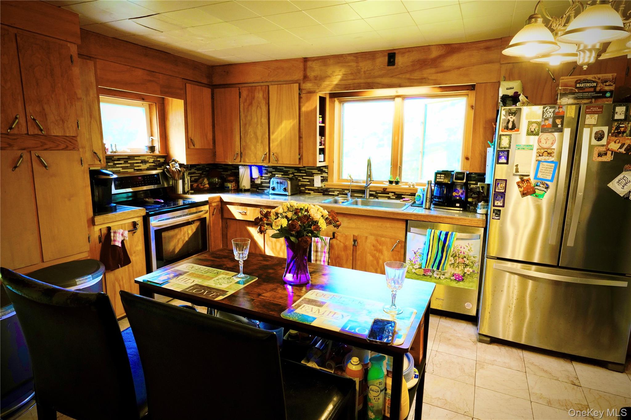 669 Shandelee Road Livingston Manor, NY 12758 - Photo 21 of 46 a kitchen with stainless steel appliances granite countertop a refrigerator a stove a sink dishwasher with a dining table and chairs