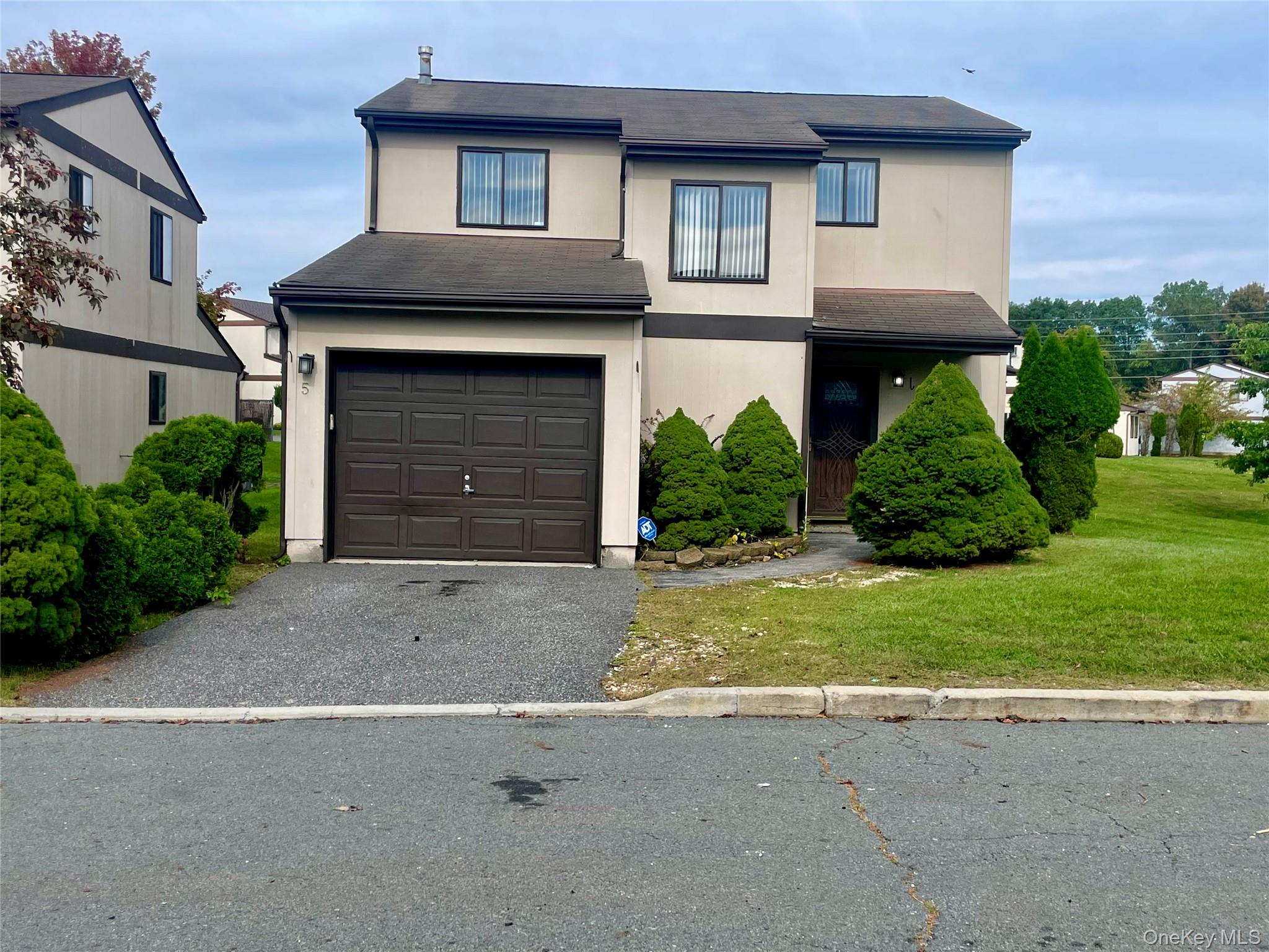 5 Raleigh Close Middletown, NY 10940 - Photo 1 of 1 Traditional home with driveway, a garage, a front yard, stucco siding, and roof with shingles