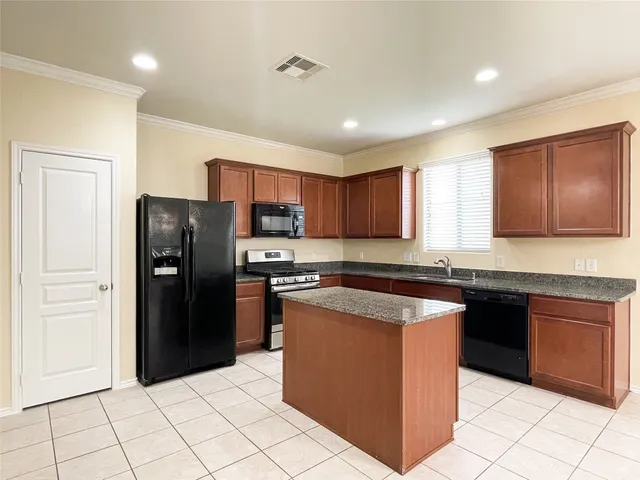a kitchen with stainless steel appliances granite countertop a stove a refrigerator and a sink