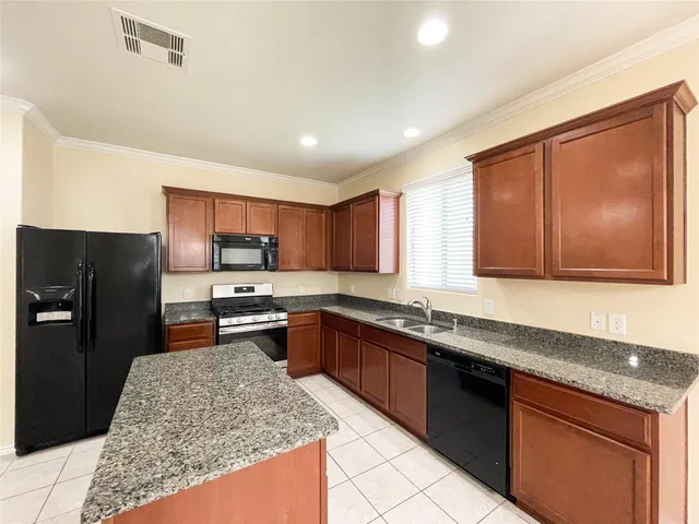 a kitchen with stainless steel appliances granite countertop refrigerator sink and stove