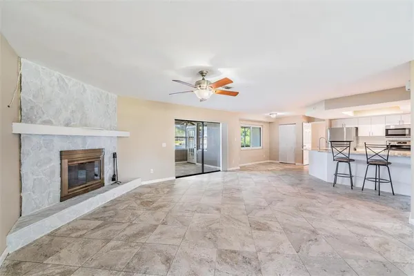 a view of an empty room with a fireplace and a window