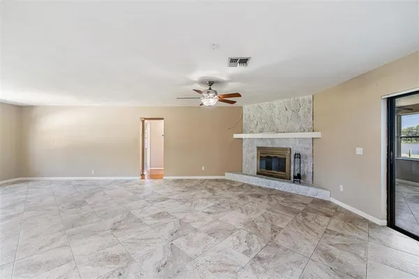 a view of empty room with a fireplace and fan