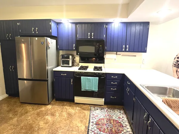a kitchen with a refrigerator sink and cabinets