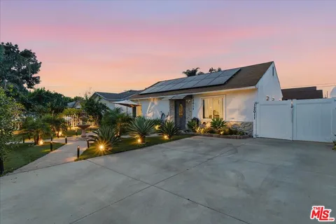 a view of a house with backyard and iron fence