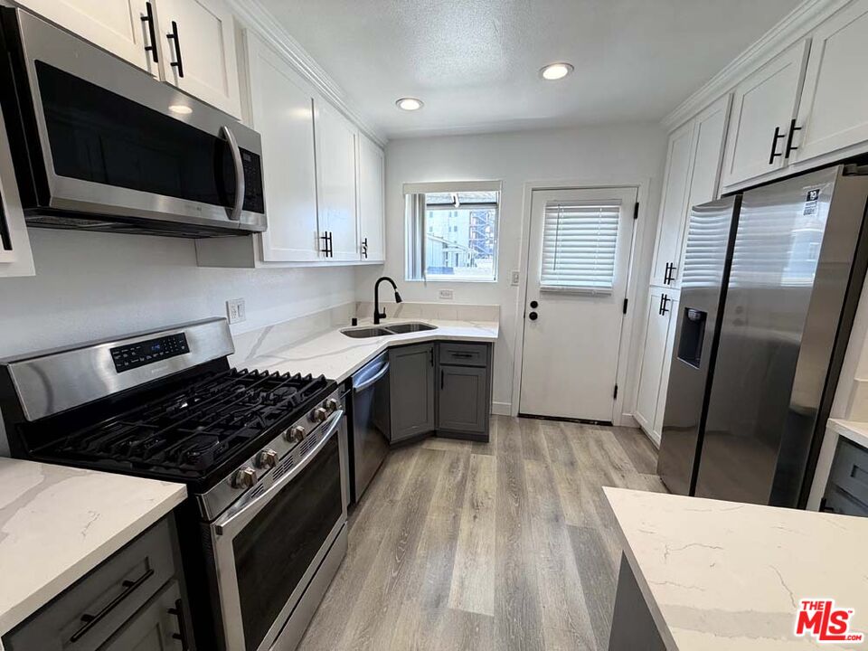 8818 Ramsgate Avenue, Unit 8822 1/2 Los Angeles, CA 90045 - Photo 6 of 20 a kitchen with a sink a stove and microwave
