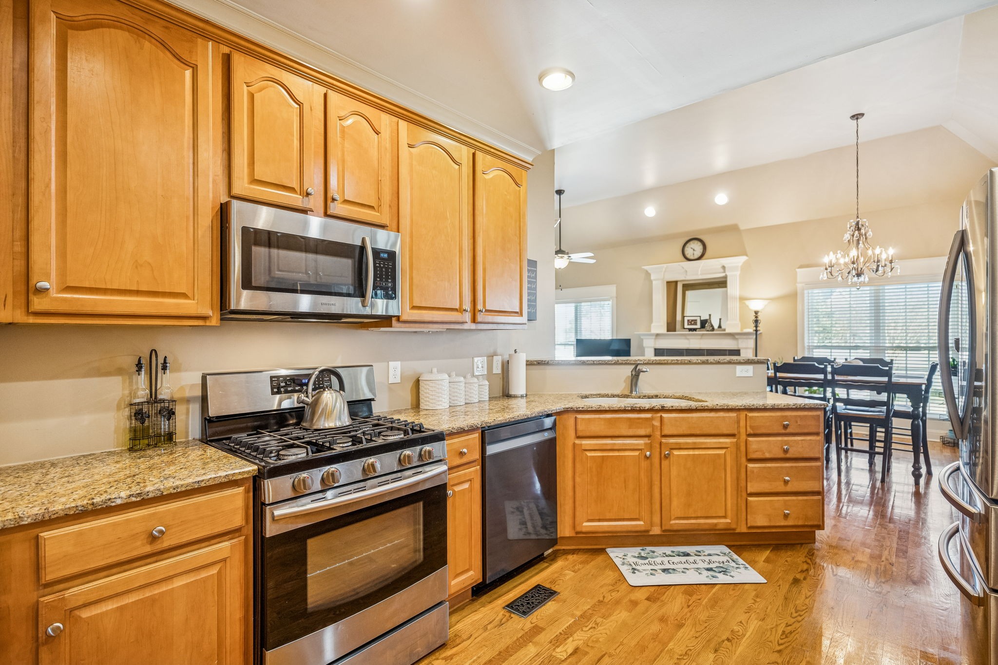 2172 Alexander Boulevard Murfreesboro, TN 37130 - Photo 16 of 46 a kitchen with stainless steel appliances granite countertop wooden cabinets a stove a sink a dining table and chairs