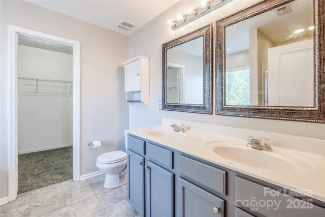 a bathroom with a sink a toilet and a mirror