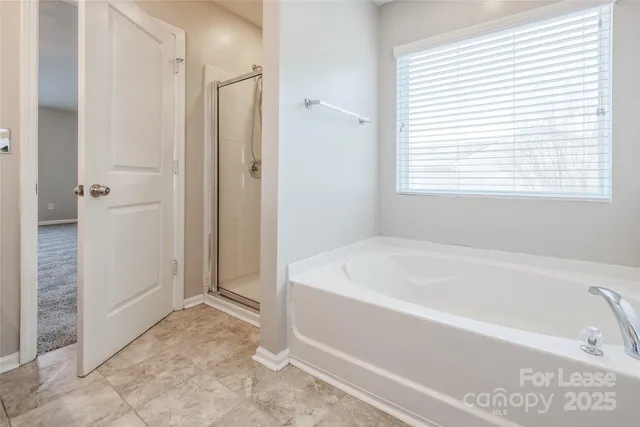 a white bath tub sitting in a bathroom next to a window