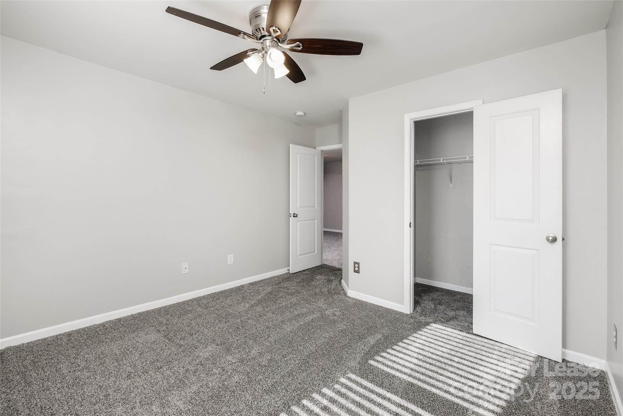 13027 Rothe House Road Charlotte, NC 28273 - Photo 23 of 31 an empty room with closet and a ceiling fan