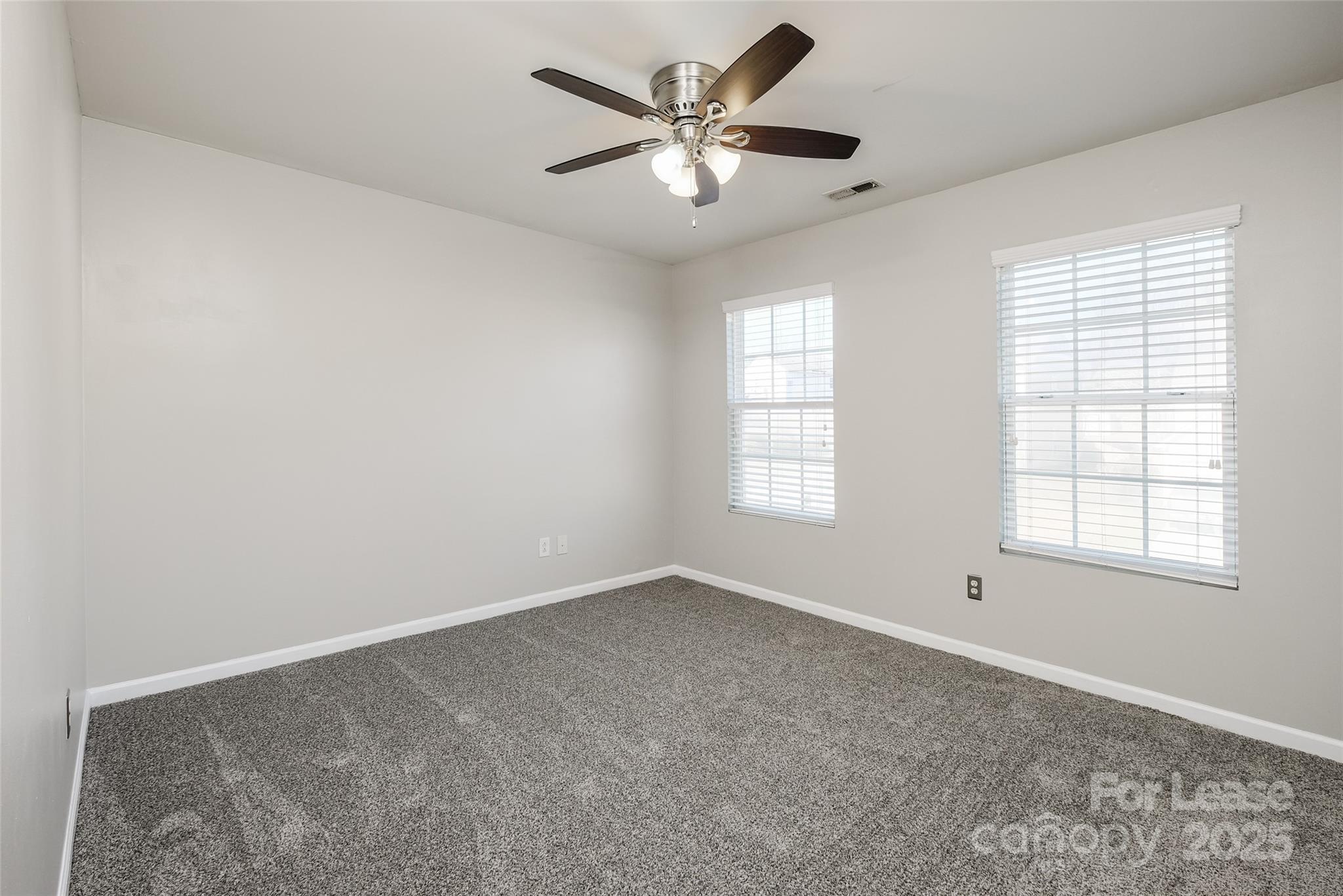13027 Rothe House Road Charlotte, NC 28273 - Photo 27 of 31 an empty room with windows and ceiling fan