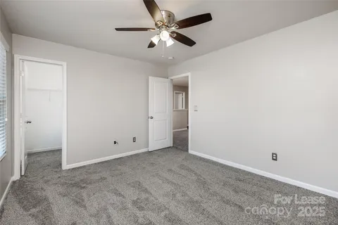an empty room with chandelier fan