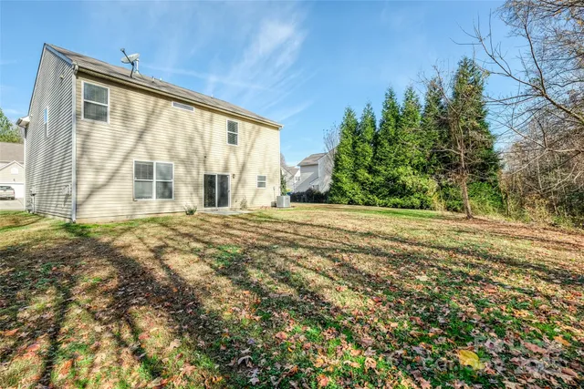 a view of an house with backyard and trees