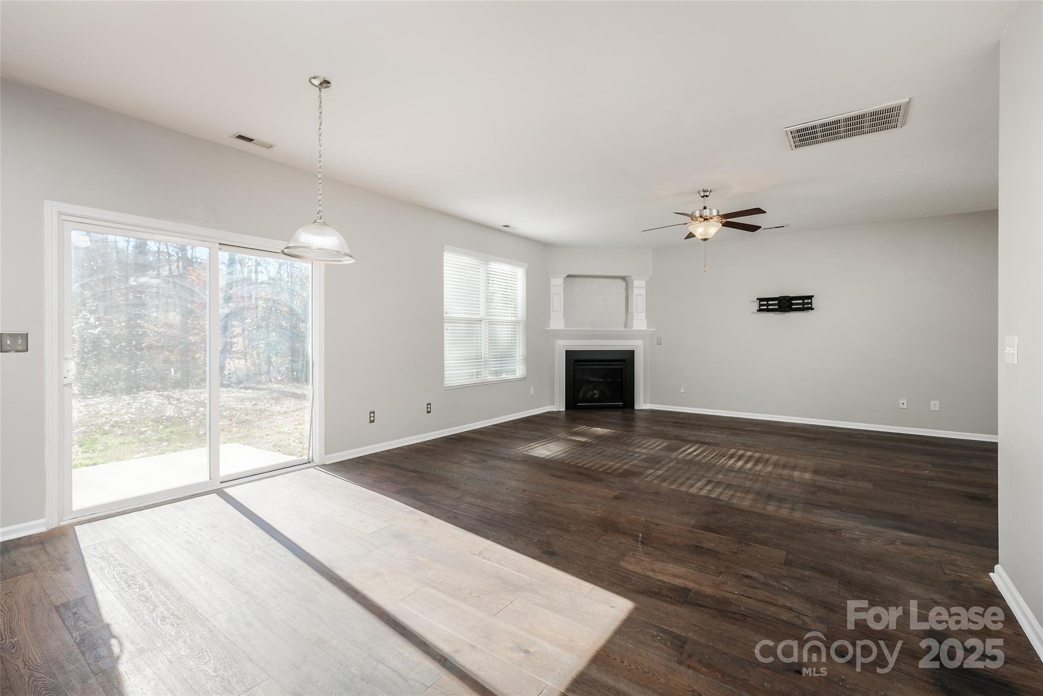 13027 Rothe House Road Charlotte, NC 28273 - Photo 6 of 31 a view of an empty room with wooden floor and a window