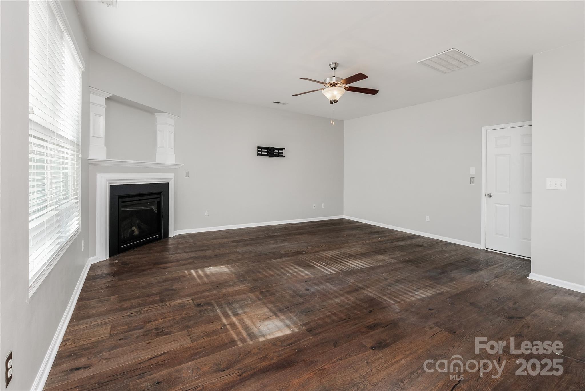 13027 Rothe House Road Charlotte, NC 28273 - Photo 7 of 31 a view of empty room with wooden floor and fireplace