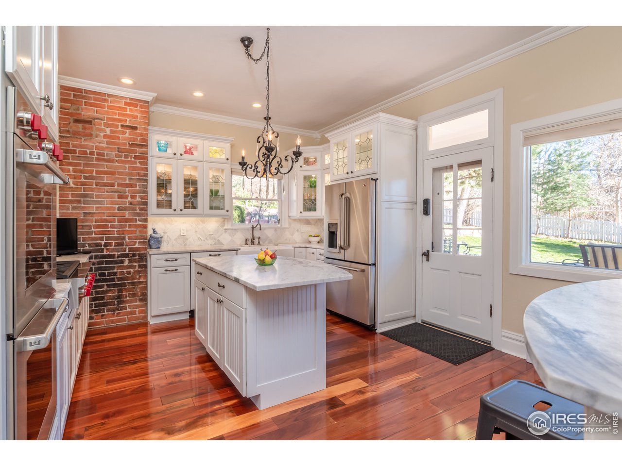 809 Pine Street Boulder, CO 80302 - Photo 8 of 38 a kitchen with stainless steel appliances kitchen island granite countertop a refrigerator a oven a stove and a wooden floors