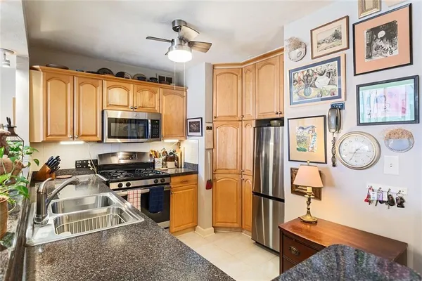 a kitchen with stainless steel appliances granite countertop a refrigerator stove top oven a sink and dishwasher