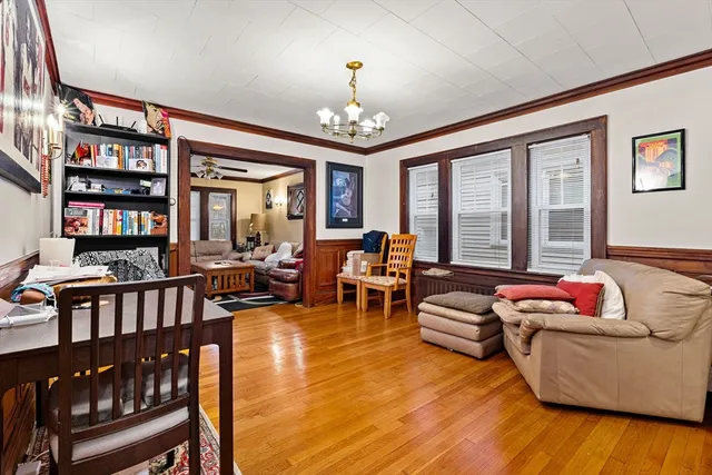 a living room with furniture floor to ceiling window and a flat screen tv