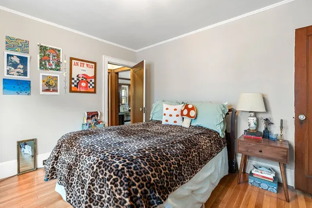 a bedroom with a bed and a lamp on dresser