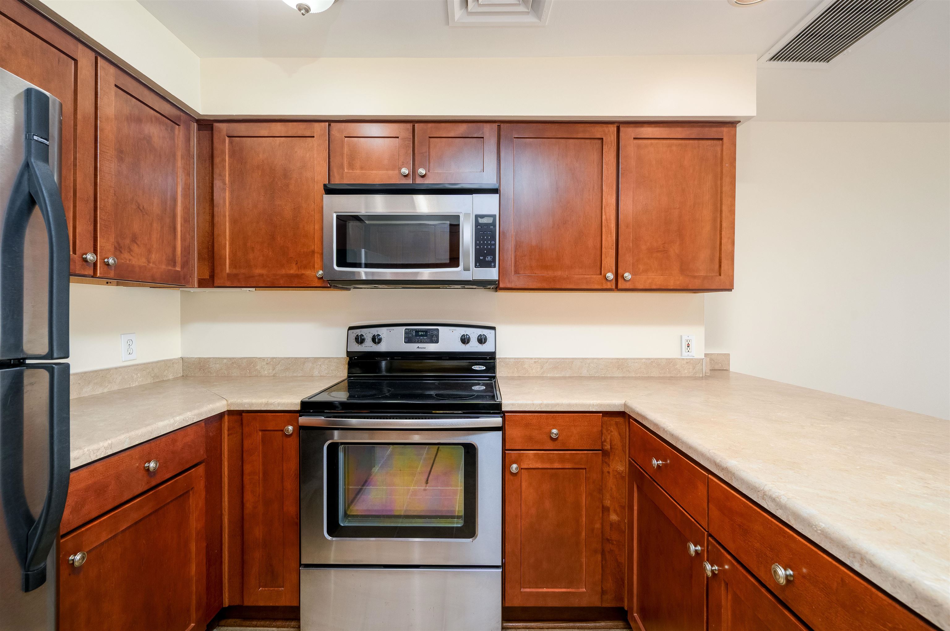 655 Riverside Drive, Unit 606A Memphis, TN 38103 - Photo 5 of 35 a kitchen with granite countertop a stove top oven microwave and cabinets