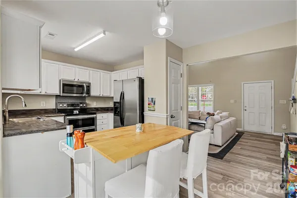 a kitchen with stainless steel appliances granite countertop a stove refrigerator and white cabinets