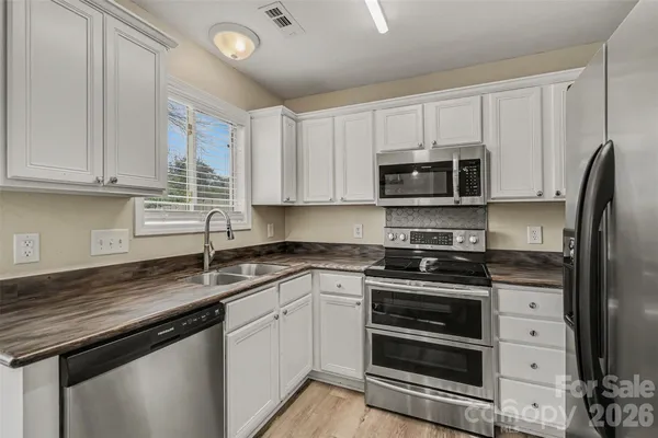 a kitchen with stainless steel appliances granite countertop a sink stove and microwave