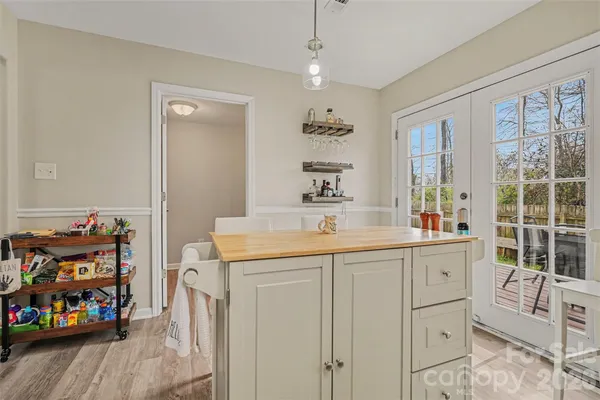 a kitchen that has a lot of cabinets in it and wooden floor
