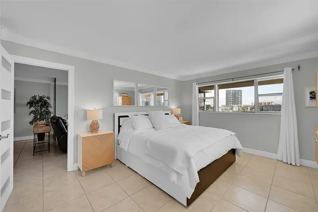 a bedroom with a bed and a large window