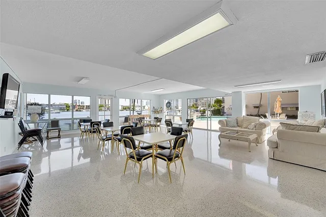 a room with lots of tables a large window and chairs