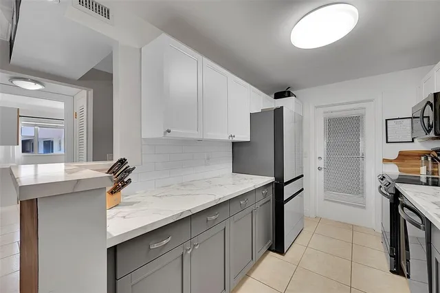 a kitchen with stainless steel appliances granite countertop a sink and a refrigerator