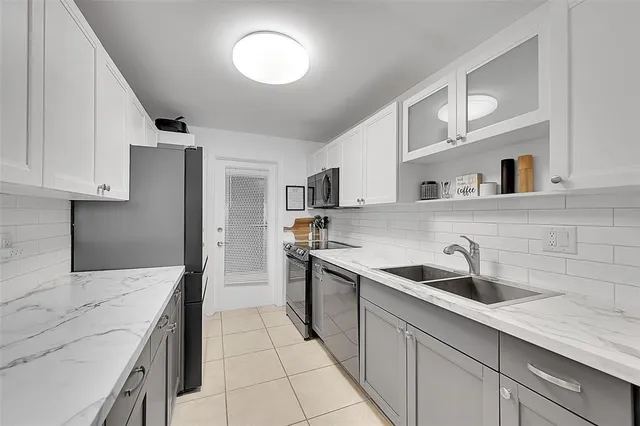 a kitchen with stainless steel appliances granite countertop a sink stove and cabinets