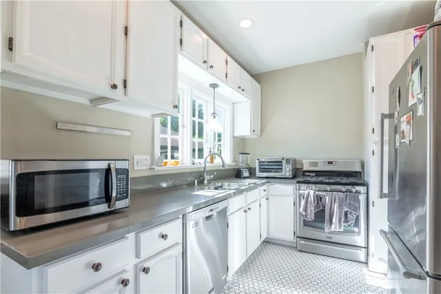 a kitchen with stainless steel appliances granite countertop a sink and a stove