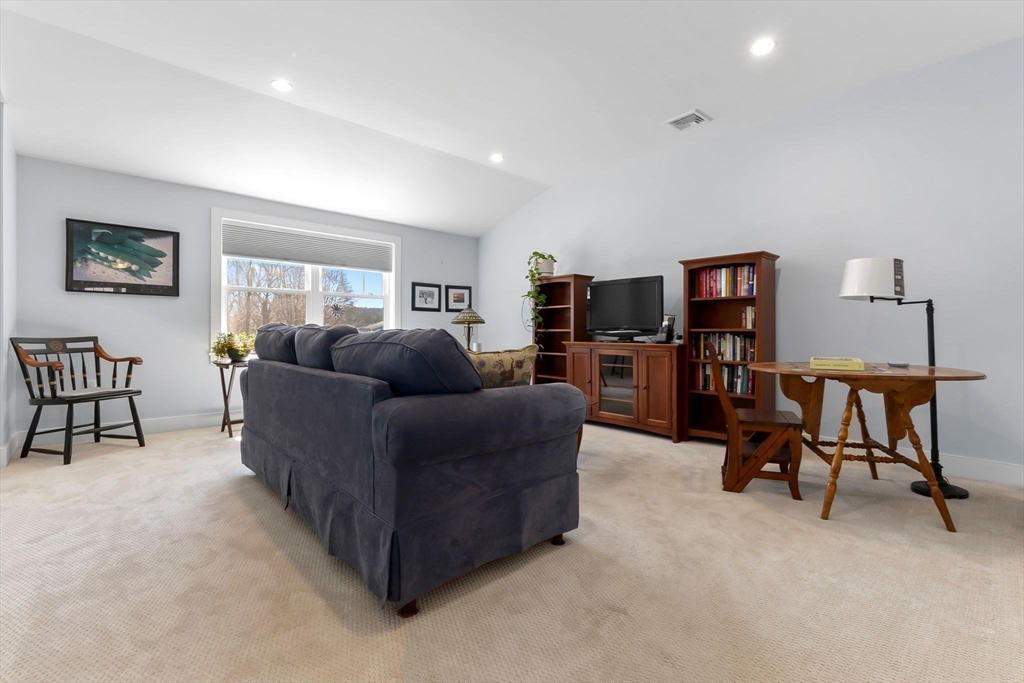 18 Primrose Lane, Unit 18 Ipswich, MA 01938 - Photo 21 of 39 a living room with furniture and a flat screen tv with wooden floor