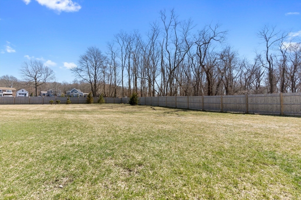 18 Primrose Lane, Unit 18 Ipswich, MA 01938 - Photo 36 of 39 a view of a yard with a house in the background