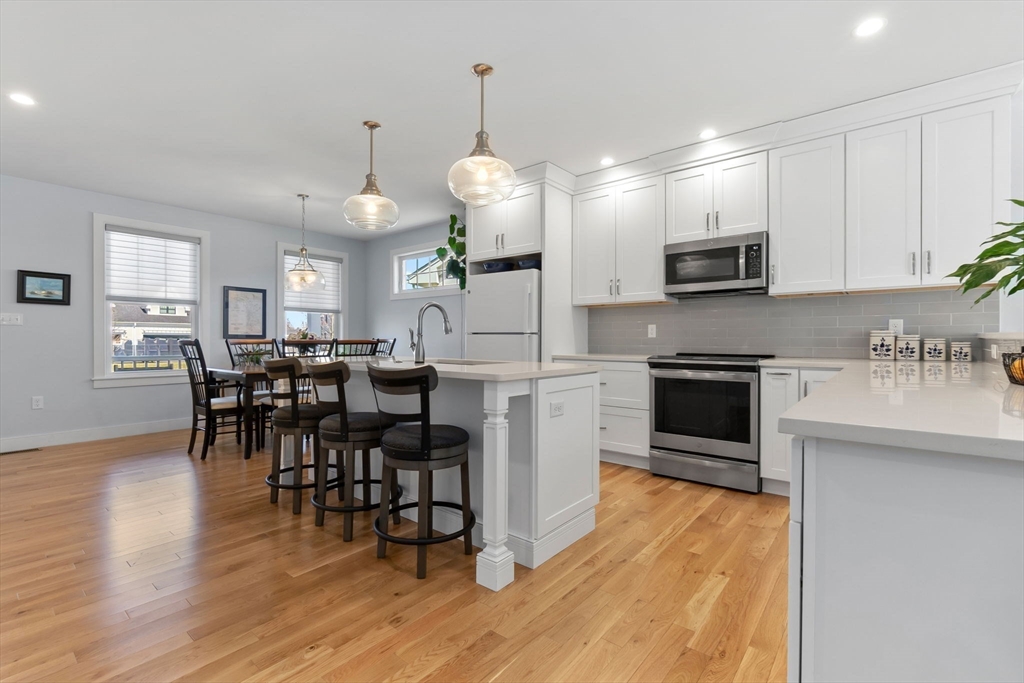 18 Primrose Lane, Unit 18 Ipswich, MA 01938 - Photo 4 of 39 a kitchen with stainless steel appliances a dining table chairs stove and microwave
