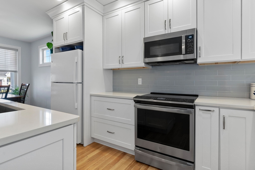 18 Primrose Lane, Unit 18 Ipswich, MA 01938 - Photo 6 of 39 a kitchen with stainless steel appliances white cabinets white stove a microwave and a refrigerator