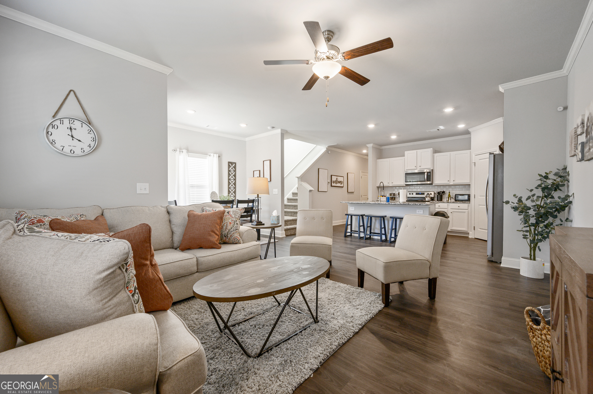 a living room with furniture kitchen view and a chandelier