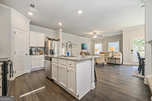 a kitchen with white cabinets and sink