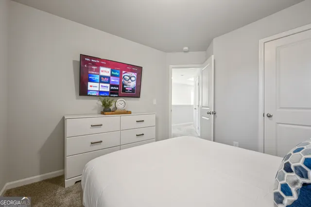 a bedroom with a bed and a flat screen tv