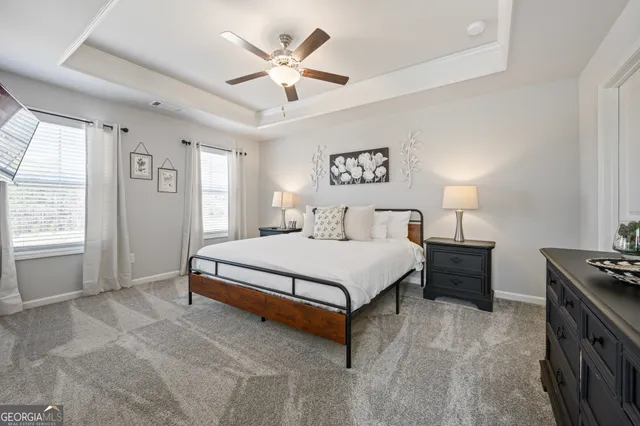 a spacious bedroom with a bed a ceiling fan and a window