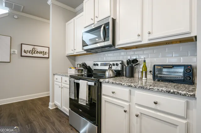 a kitchen with stainless steel appliances granite countertop a sink a stove and a microwave