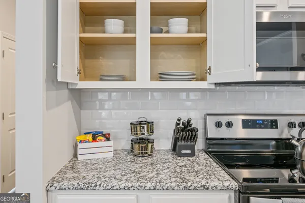 a kitchen with a stove a microwave and cabinets