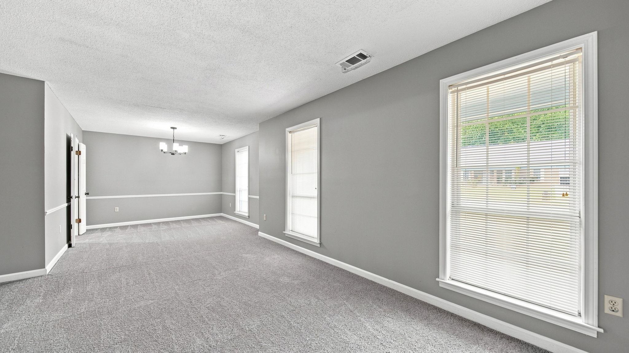 4920 Whitworth Road Memphis, TN 38116 - Photo 10 of 32 Spacious room featuring neutral carpeting, light gray walls, white trim, and multiple windows