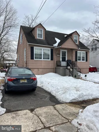 a front view of a house with cars parked